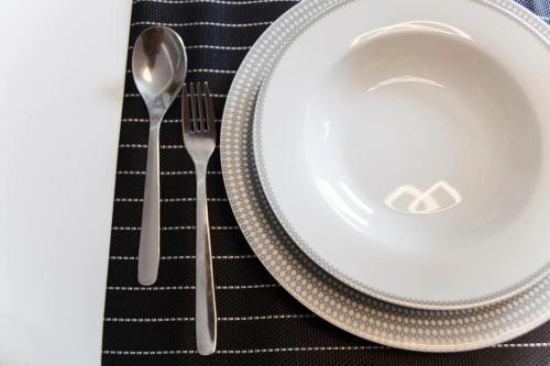 a plate and a fork and spoon on a table at Minimal Loft Art with Sea View Over Heraklion Harbour in Heraklio Town