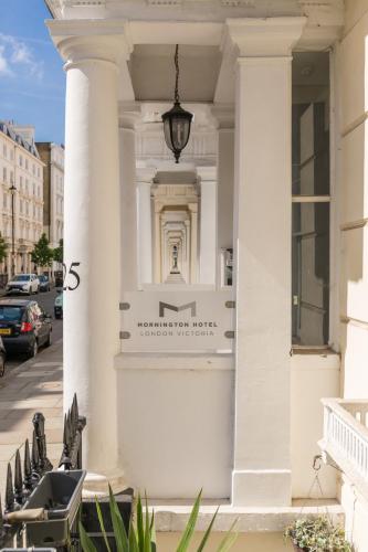 a white building with a sign on the front of it at Mornington Hotel London Victoria in London