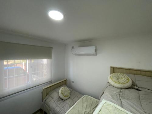 a small bedroom with two beds and a window at Quinta con Jacuzzi - Desconectá in Concepción del Uruguay