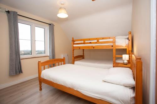 2 Etagenbetten in einem Zimmer mit Fenster in der Unterkunft Brittas Bay Holiday Village No 32 in Brittas Bay