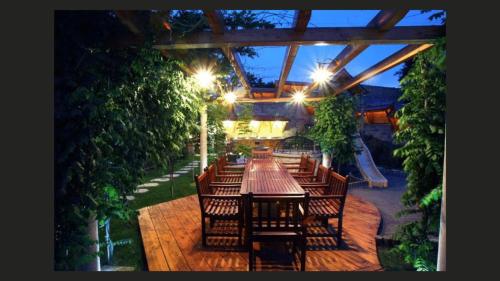 a restaurant with a long table and chairs with lights at Kulacs Csarda Panzio in Eger