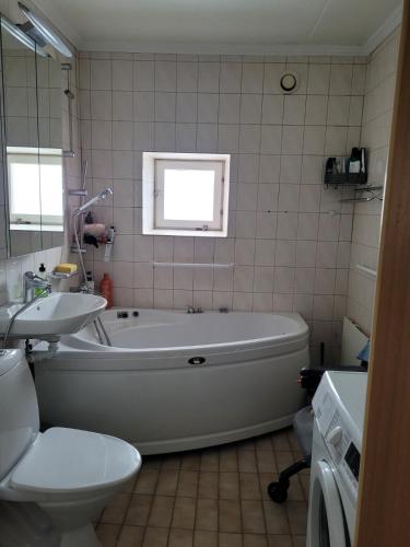 a bathroom with a tub and a sink and a toilet at Sunny ROOM in Stockholm in Stockholm