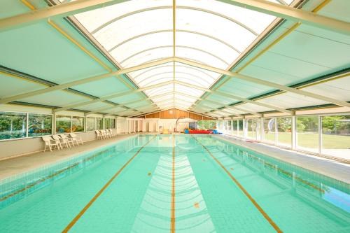 a large indoor swimming pool with a glass ceiling at Glamping Drenthe in Meppen