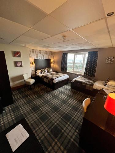 a hotel room with a bed and a couch at Inn On The Prom At The Fernlea Hotel in Lytham St Annes