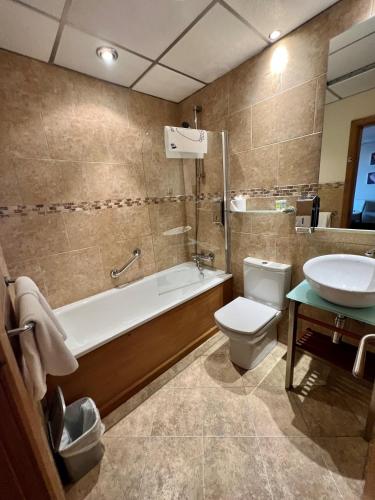 a bathroom with a tub and a toilet and a sink at Inn On The Prom At The Fernlea Hotel in Lytham St Annes