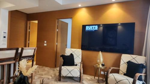 a waiting room with two chairs and a large screen at Studio Haut standing Casa finance City Tour Vegetale Yasmine Signature Résidence in Casablanca