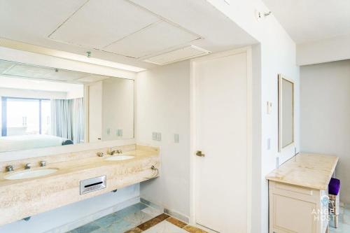 a bathroom with a sink and a mirror at Fabulous Oceanview Suite with Private Jacuzzi plus Access to Beach&Pools in Cancún