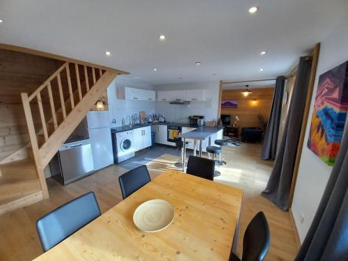 Una cocina y un comedor con mesa y sillas de madera. en LE ZÈDÈL - Duplex 100m2 vue montagne, au cœur de la Savoie, au pied des stations de ski, en Aigueblanche