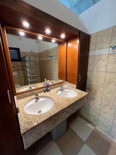 baño con 2 lavabos y espejo grande en Vrijstaande BB BEACH Villa Azure, en Blue Bay