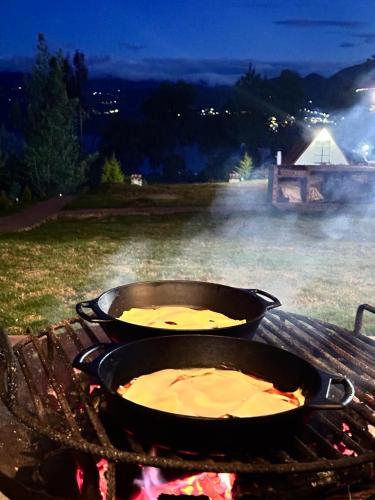 two pans of food are cooking on a grill at TOSCANA de Tomine in Guatavita