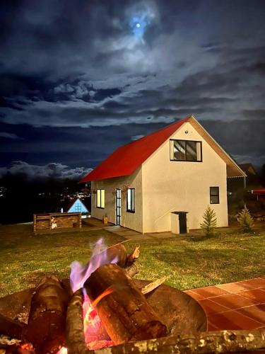 a person laying over a fire in front of a house at TOSCANA de Tomine in Guatavita