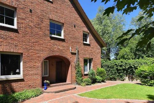 旺格兰Ferienwohnungen Janssen-Graalfs的砖房,有门和院子