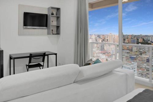 a white living room with a white couch and a window at Apartamento em Osasco com Piscina Aquecida e Ar condicionado in Osasco