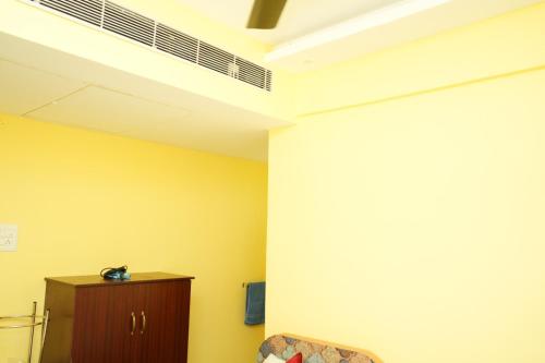a room with yellow walls and a white ceiling at H2 Residency in Rāmanāthapuram