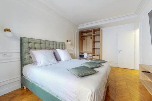 une chambre avec un grand lit blanc avec deux oreillers dans l'établissement Arc de Triomphe - Triangle d’or, à Paris