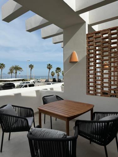 a patio with a table and chairs and a view of the beach at Reyes Católicos Premium Beach, Playa Urbanova, Alicante in Alicante