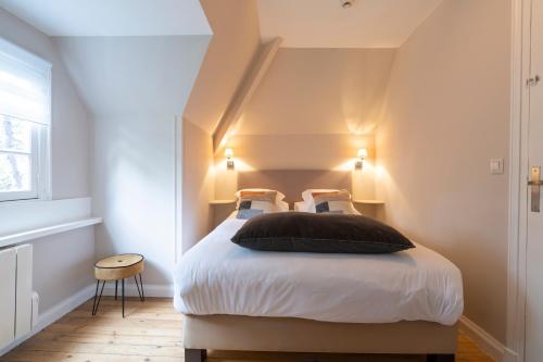 a bedroom with a bed with two pillows on it at Demeure d'Hôtes Haec Otia in Le Touquet-Paris-Plage
