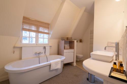 un bagno bianco con vasca e lavandino di Demeure d'Hôtes Haec Otia a Le Touquet-Paris-Plage