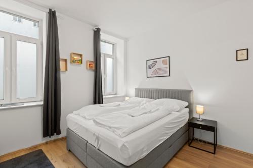 - une chambre avec un lit doté de draps blancs et une fenêtre dans l'établissement StayEasy Apartments Vienna A#3, à Vienne