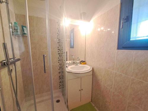La salle de bains est pourvue d'un lavabo et d'une douche. dans l'établissement Studio cabine avec piscine et parking à Marseillan - FR-1-326-607, à Marseillan