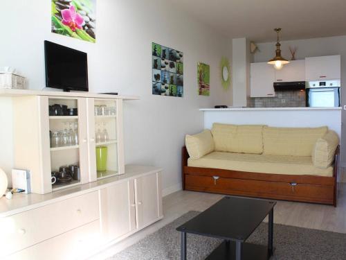 un salon avec un canapé et une cuisine dans l'établissement Appartement front de mer à La Baule : T2 avec terrasse, parking et Wifi - FR-1-245-120, à La Baule