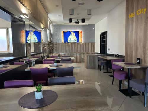 ein Restaurant mit Holztischen und lila Stühlen in der Unterkunft Garni Hotel Niš City View in Niš