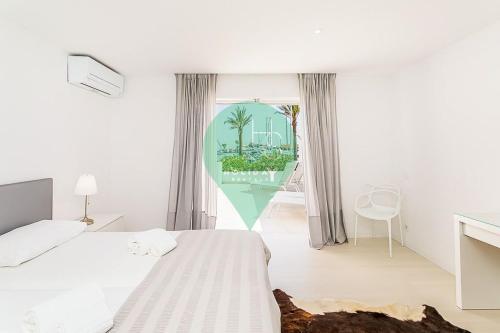 a white bedroom with a bed and a window at Vista dos Seus Sonhos T2 HsR Vilamarina in Quarteira