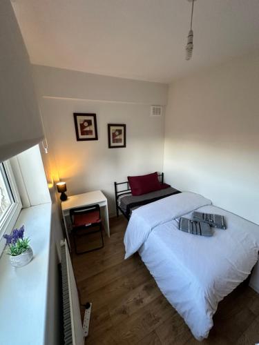 a bedroom with a large white bed and a table at Victoria Park House R1 in London