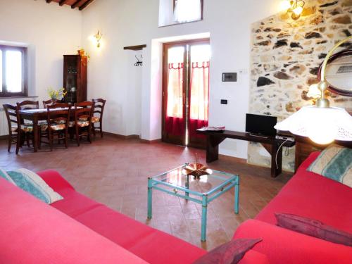 sala de estar con sofá rojo y mesa en Apartment Fienile by Interhome, en Sasso Pisano