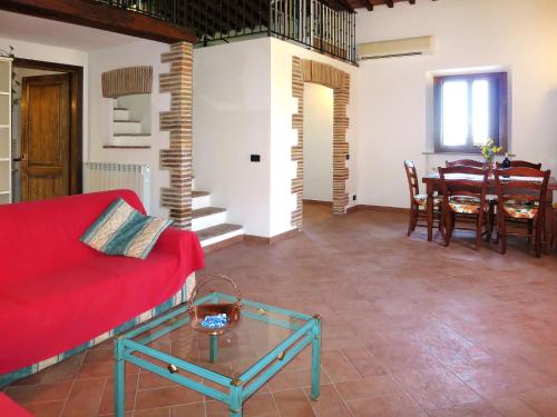 een woonkamer met een rode bank en een tafel bij Apartment Fienile by Interhome in Sasso Pisano