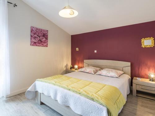 um quarto com uma cama e uma parede roxa em Gîte Saint-Julien-de-Concelles, 4 pièces, 6 personnes - FR-1-306-815 em Saint-Julien-de-Concelles