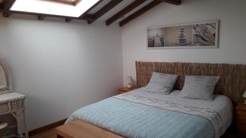 a bedroom with a bed with a blue comforter at Maison Florenchaenia sur le Chemin de Compostelle in Saint-Jean-Pied-de-Port