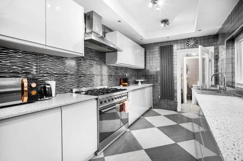 a kitchen with white cabinets and a checkered floor at Stylish 4 Bedroom Townhouse - Edgbaston - Near Birmingham City Centre - Sleeps 8 - Parking - 578P in Birmingham