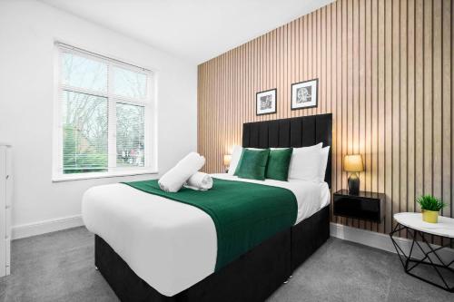 a bedroom with a large bed with green and white pillows at Stylish 4 Bedroom Townhouse - Edgbaston - Near Birmingham City Centre - Sleeps 8 - Parking - 578P in Birmingham