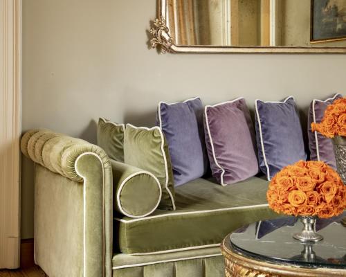 a living room with a couch with purple and purple pillows at Grand Hotel Tremezzo in Tremezzo