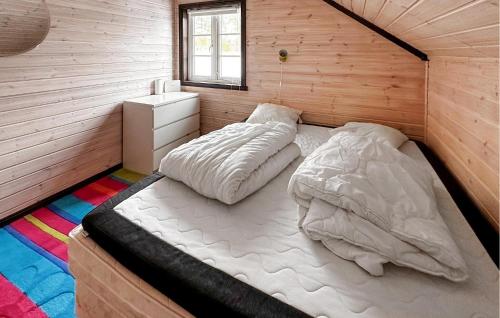 a bedroom with two beds in a wooden room at 4 Bedroom Awesome Home In Rysstad in Rysstad
