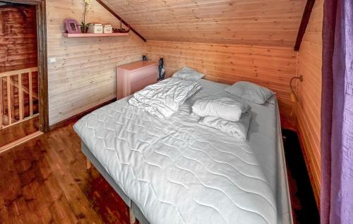 a large bed in a small room with wooden walls at 4 Bedroom Beautiful Home In Rysstad in Rysstad