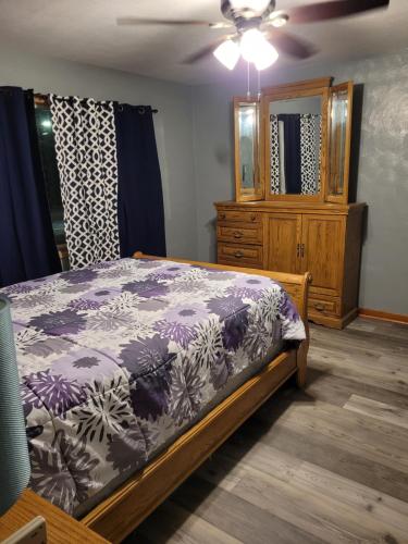 a bedroom with a bed and a dresser at Travelers Guesthouse in Greenfield