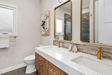 a bathroom with a sink and a toilet and mirrors at Caviar Dreams In The Heart of Hillcrest in San Diego