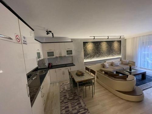 a kitchen and living room with a couch and a table at Daily Apartment Prishtina in Pristina