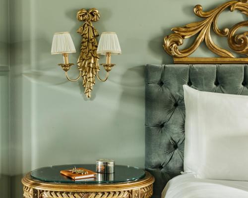 a bed with a table with two lamps on it at Grand Hotel Tremezzo in Tremezzo