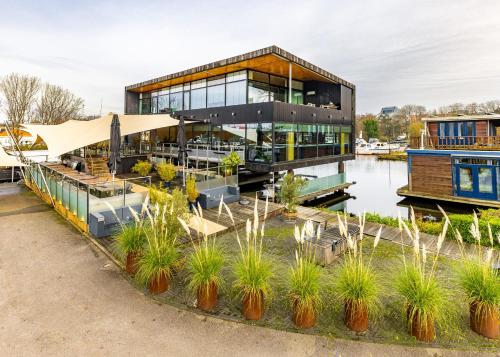 a house on the water with plants in front of it at Motor Yacht Amstelle in Amsterdam