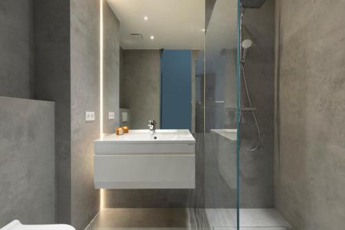 a bathroom with a sink and a shower at Elite Apartments Wałowa Studio in Gdańsk