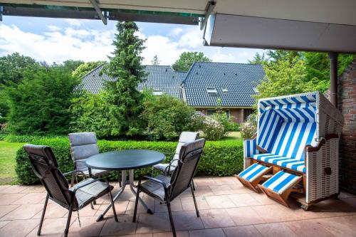 einen Terrassentisch und Stühle auf einer Terrasse in der Unterkunft Wohnen am Südstrand 02 in Wyk auf Föhr