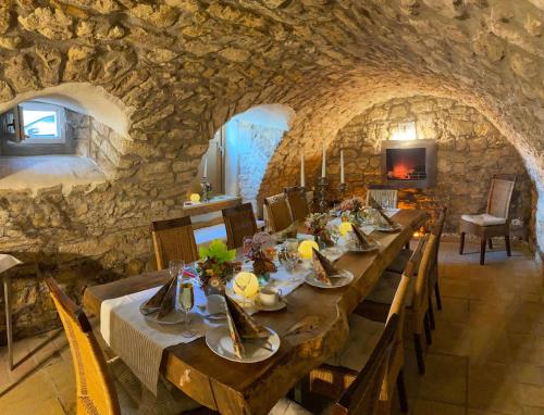 a dining room with a long table in a stone wall at Geibelhof in Karben
