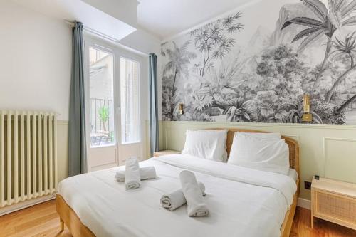 - une chambre avec un grand lit blanc et des oreillers blancs dans l'établissement MyKeypers - Design & Cosy Flat 2BR Center Paris - Moulin Rouge, à Paris