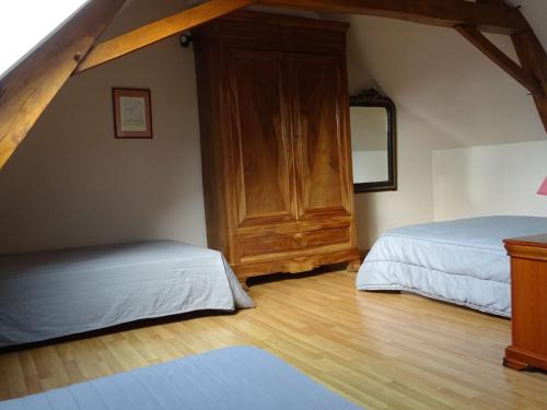 a bedroom with two beds and a wooden cabinet at Gîte familial avec jardin et vélos, proche Le Mans - FR-1-410-146 in Saint-Gervais en-Belin