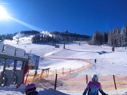 a group of people skiing down a snow covered slope at Apratmán Julie – Bavorská Ruda in Bayerisch Eisenstein