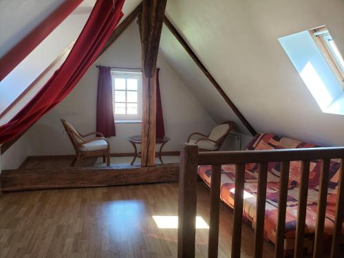 Camera mansardata con letto, tavolo e sedie. di Charmante maison paysanne rénovée avec grand terrain, proche de la rivière et du village médiéval - FR-1-410-162 a Asnières-sur-Vègre