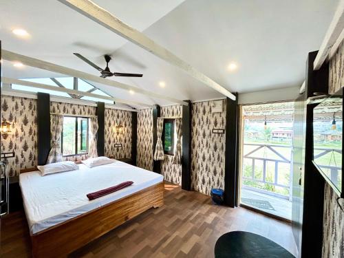 a bedroom with a bed and a large window at Palli Bangla Resort, near Ruby Hospital, Anandapur in Kolkata
